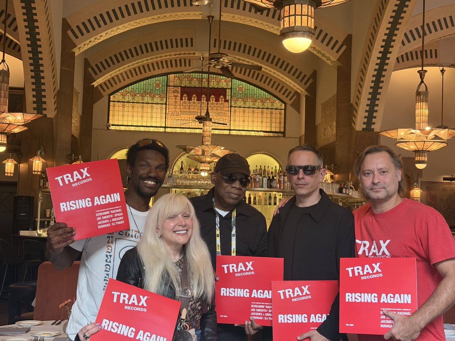 DJ THÄDX with the TRAX Records group holding Rising Again vinyl in Amsterdam